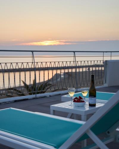 a table with two glasses of wine and a bowl of fruit at Via Firenze 11 in Follonica