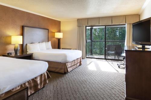 a hotel room with two beds and a balcony at Valley River Inn Eugene/Springfield in Eugene
