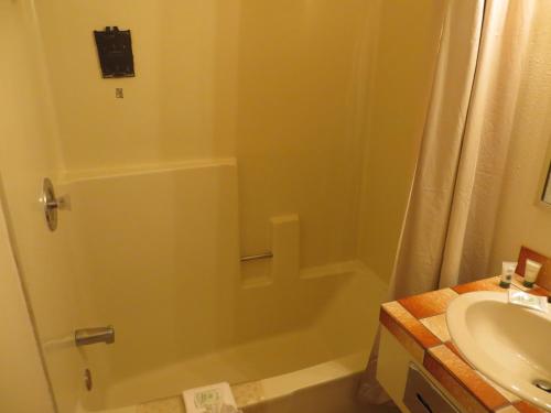 a bathroom with a toilet, sink, and bathtub at Saddle West Casino Hotel in Pahrump
