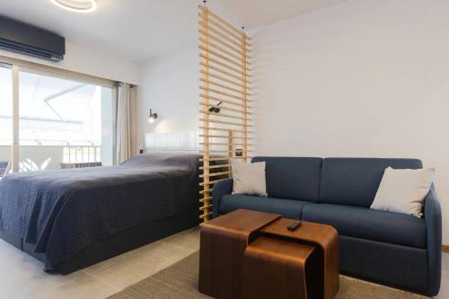 a bedroom with a bed and a blue couch at Cannes NEW Apartment, Palais Des Festivals, CROISETTE, Beaches in Cannes