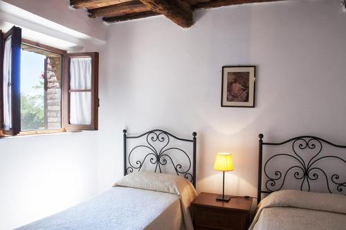 1 dormitorio con 2 camas, lámpara y ventana en Azienda Agricola di Fietri, en San Vincenti