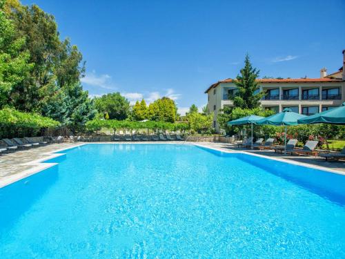 a large swimming pool with chairs and umbrellas at Hotel Europa Olympia in Olympia