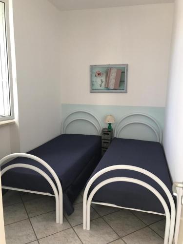 a bedroom with two beds with blue sheets at Brezza di Mare in Torre Canne
