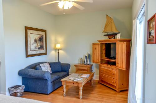 a living room with a blue couch and a tv at The Sunset Inn in Sunset Beach