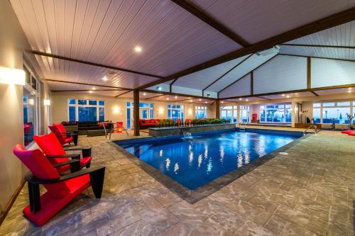 リビエール・デュ・ルーにあるAuberge de la Pointeの赤い椅子付きの家のプール