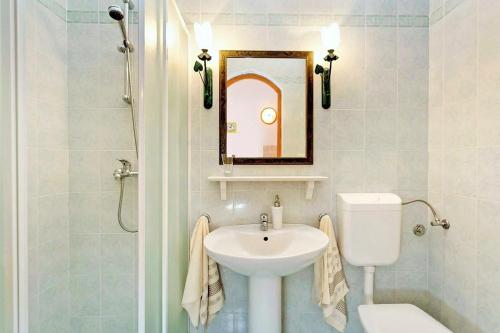 een badkamer met een wastafel, een toilet en een spiegel bij Apartments Sara in Bale
