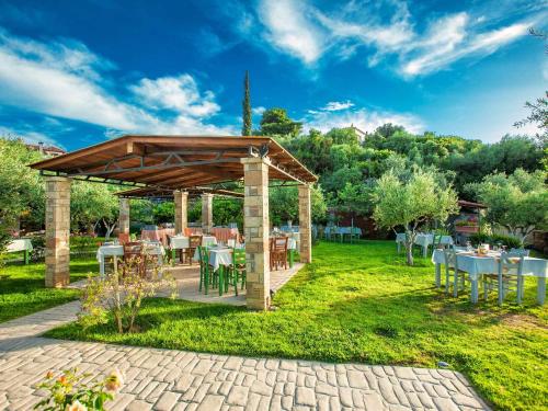 a pavilion with tables and chairs in a garden at Hotel Europa Olympia in Olympia
