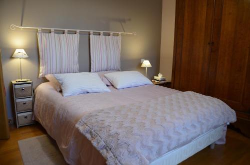 1 dormitorio con 1 cama blanca grande y 2 almohadas en le logis du scardon en Saint-Riquier