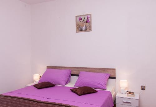 1 dormitorio con 1 cama de color púrpura y 2 almohadas de color púrpura en Nadalina Apartment, en Kaštel Stari