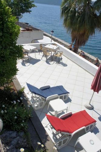 a patio with chairs and tables and the ocean at Apartmani Milosevic in Herceg-Novi