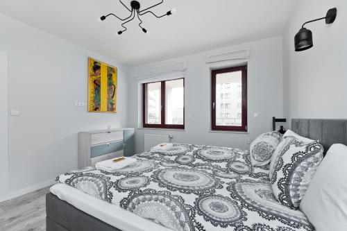 a white bedroom with a large bed and windows at Ludwinowska11 Apartments in Kraków