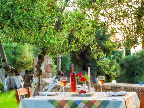 a table with a bottle of wine and glasses at Hotel Europa Olympia in Olympia