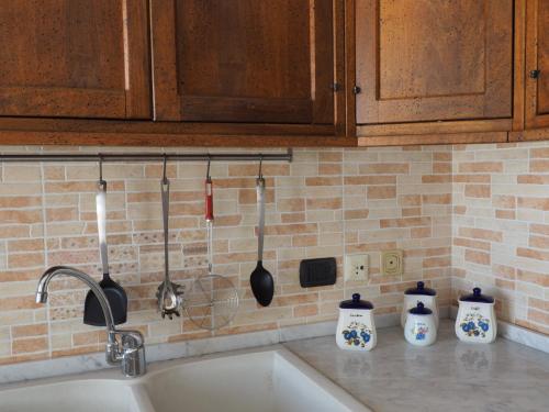 um lavatório de cozinha com utensílios na parede em Casa vacanza Laila em Cassina deʼ Pecchi