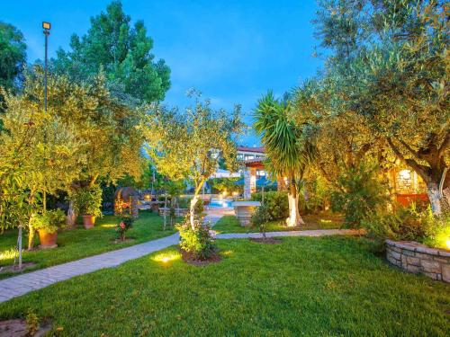 a garden with trees and lights on the grass at Hotel Europa Olympia in Olympia