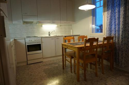 a kitchen with a table and chairs and a stove at Kappelinrannan Asunnot in Pargas