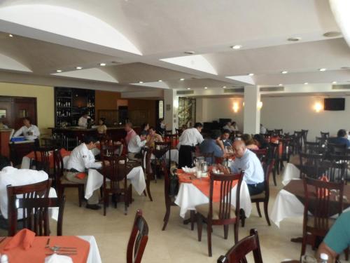 a group of people sitting at tables in a restaurant at Hotel Poza Rica Inn in Poza Rica de Hidalgo