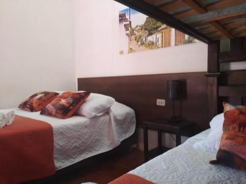 a bedroom with two beds and a window at Hotel Casa del Marquez de Bahichala in Barichara