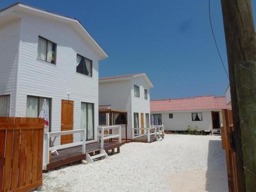 a group of houses on a dirt yard at Casa Ananda in Punta de Choros