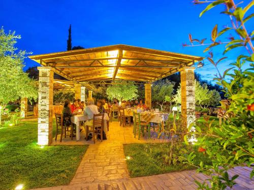 a patio with tables and chairs under a wooden pergola at Hotel Europa Olympia in Olympia