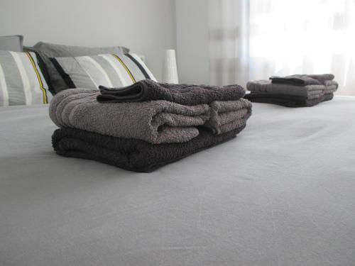 a pile of towels sitting on top of a bed at Playa Elisa Bay in Pilar de la Horadada