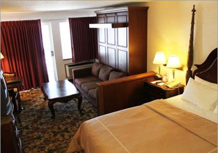 a hotel room with a bed and a couch at Crown Choice Inn & Suites Lakeview and Waterpark in Mackinaw City