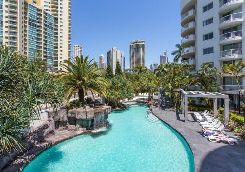 an infinity pool at a resort with palm trees at Sovereign on the Gold Coast in Gold Coast