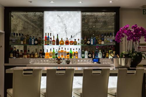 a bar with a lot of bottles of alcohol at Mosaic Hotel Beverly Hills in Los Angeles