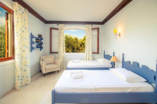 2 camas en una habitación con ventana en La Belle Villa, en Akrotiri