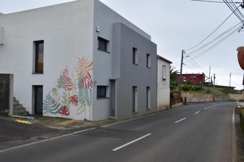 a white building with a mural on the side of it at Casa do Dragoeiro in Angra do Heroísmo