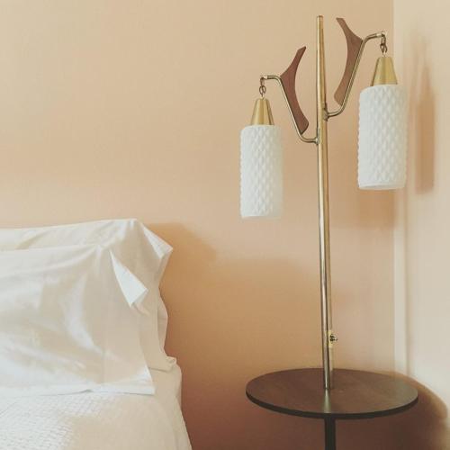a lamp on a table next to a bed at Holiday Music Motel in Sturgeon Bay