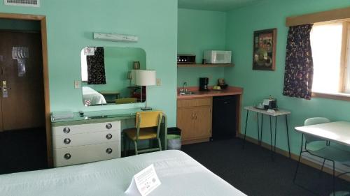 Pokój z łóżkiem, biurkiem i lustrem w obiekcie Holiday Music Motel w mieście Sturgeon Bay