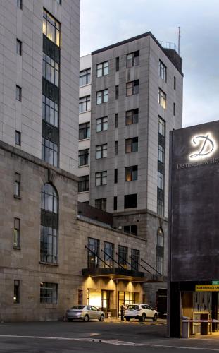 two cars parked in front of a building at Distinction Dunedin Hotel in Dunedin