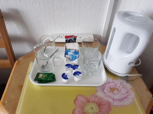 einen Tisch mit einem Tablett mit Glasvasen darauf in der Unterkunft Fairhaven Guest Accommodation in Nottingham