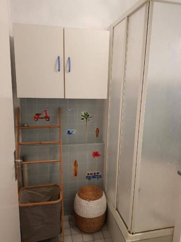 - une salle de bains avec une armoire blanche et un panier dans l'établissement AICE HEGOA avec Parking Inclus, à Saint-Jean-de-Luz