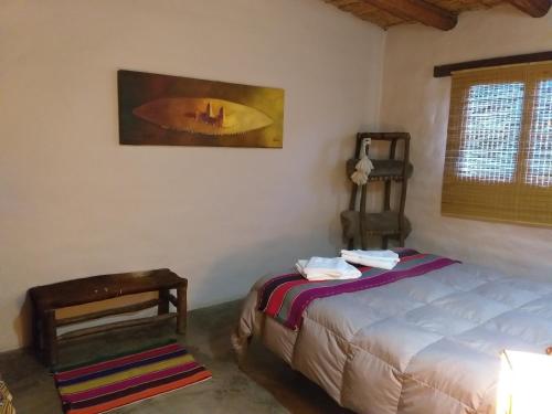 a bedroom with a bed and a table and a window at Sendero De Las Cabras in Purmamarca