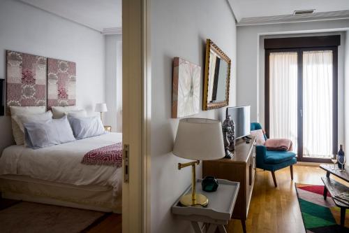 1 dormitorio con 1 cama y 1 mesa con lámpara en Figueroa Design en Madrid