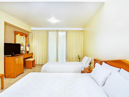 a hotel room with two beds and a television at Hotel Europa Olympia in Olympia