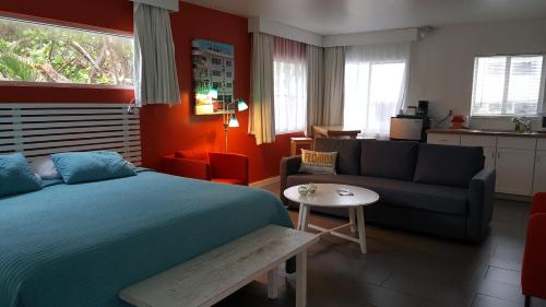 a bedroom with a bed and a couch and a table at Snooze in Fort Lauderdale