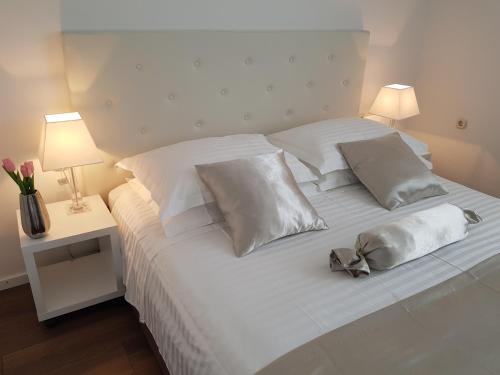 Cama blanca con sábanas y almohadas blancas en Apartment Tisno Residence en Tisno