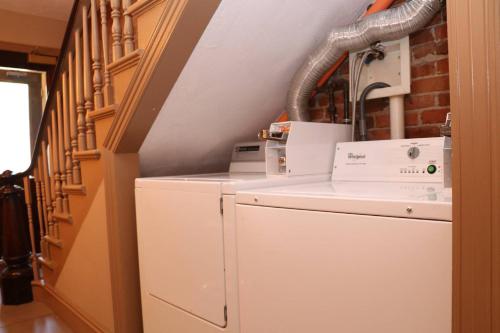 a washer and dryer in a room with a staircase at Stylish Downtown Studio in the South End, #8 in Boston