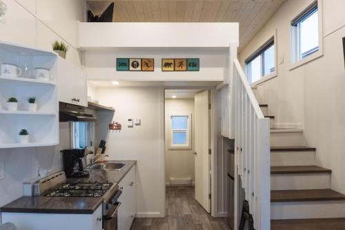 a kitchen with a staircase leading up to a loft at Tiny Homes by Snow Valley Lodging in Fernie