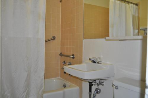 a bathroom with a sink and a tub and a toilet at Budget Inn Express Helena in Helena