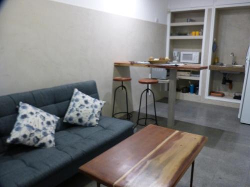 - un salon avec un canapé bleu et une table en bois dans l'établissement Departamento Tu Hogar de Paso, à Mendoza