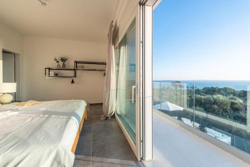 a bedroom with a bed and a large glass window at Villa Olea, luxury retreat with nature blend in Novalja