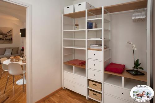 een kast met witte planken en een bureau in een kamer bij LA CASA DI GLADYS in Lecco