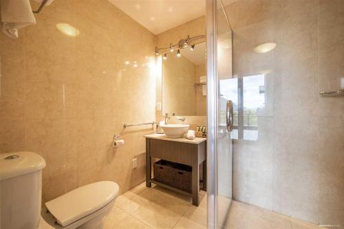 a bathroom with a toilet and a sink and a shower at The Beacon - Luxe Studio Unit in Queenstown