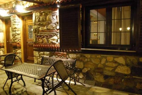 a patio with a table and chairs in front of a stone building at Tzivaeri in Likodhrómion