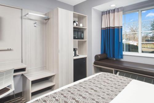 a bedroom with a bed and a desk and a window at Microtel Inn & Suites by Wyndham Bethel/Danbury in Bethel