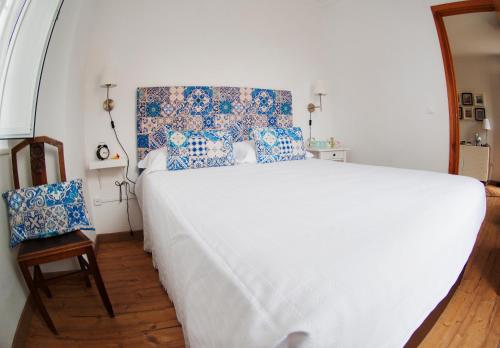 um quarto com uma cama grande e almofadas azuis e brancas em Belém Apartment em Lisboa