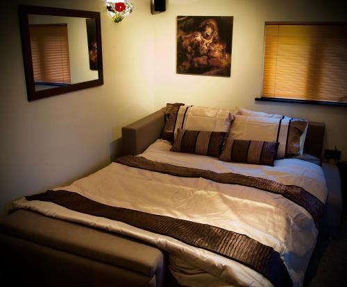 a bed in a bedroom with a large bedvisor at Luxurious Rural Cabin with Hot Tub in West Chiltington